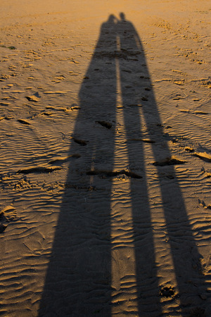 sea side shadows Playing with shadows in the late evening sun on the beachの写真素材
