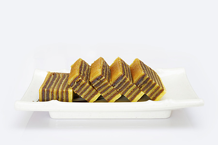 Multi-layered cake called "lapis legit" or "spekkoek" from Indonesia, isolated on white background.の写真素材