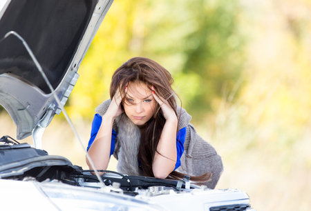 sad girl with beautiful hair at broken car