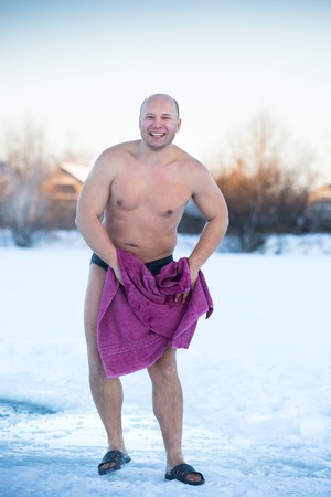 man wipes towel on a cold day outdoorsの写真素材