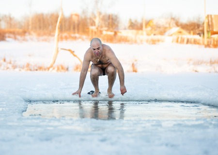 Winter-swimmer in ice-hole at lake a frosty morningの写真素材