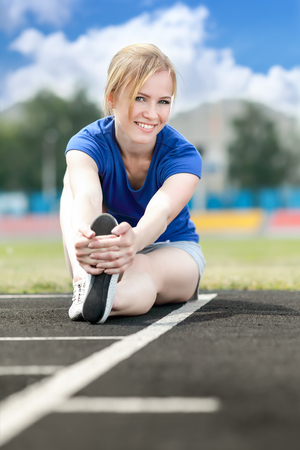 woman doing core workout at a stadiumの写真素材