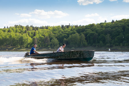 funny family riding  hand motorboat in lake