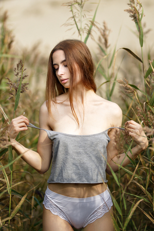 Outdoors portrait of a beautiful woman undressesの写真素材