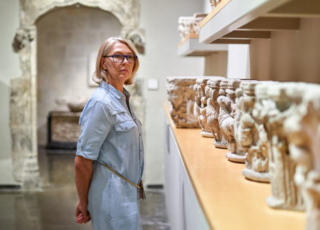 woman visitor in historical museum looking at art objectの写真素材