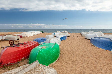 Several colorful fishing boats by the sea on a sunny day.