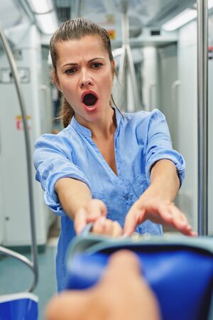 Scared woman face.Thief takes bag at subway station.の写真素材