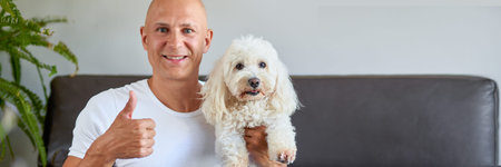 Handsome man with cute white dog at home