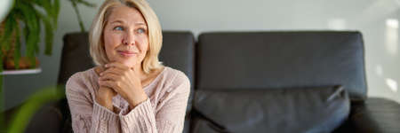Close up Pretty Adult Woman Sitting on Sofa Looking at the Camera.の写真素材