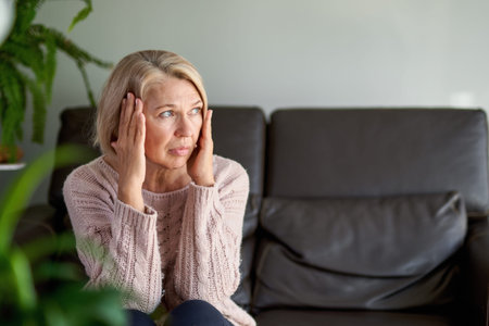 Woman suffering from a headache and stress holding her hands to her temples