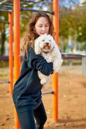 Young attractive sport girl doing exercises with dog at outdoor
