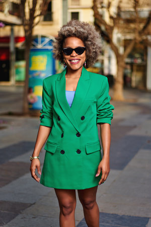 Portrait of attractive positive curly hairstyle dark skin lady smile free time outdoorsの写真素材