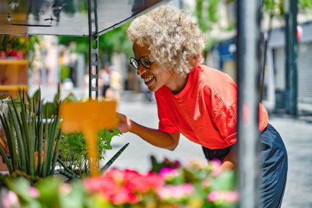 A woman buyer selects bouquets before buying at a flower shop on the streetの写真素材