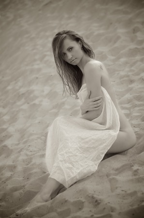 Young woman sitting on the sandの写真素材