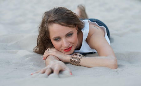Young woman lying on the sandの写真素材