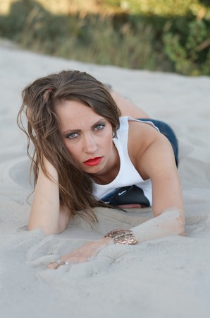 Young woman lying on the sandの写真素材
