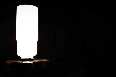 Table lamp on a dark background. To the right of the lamp is an excellent place for inscription or editing.の写真素材