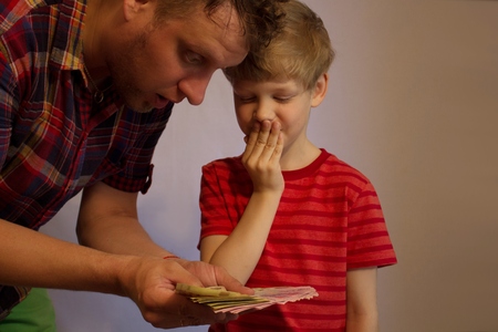Man and boy hold money in their hands.  They are looking at money. In their eyes, surprise.の写真素材