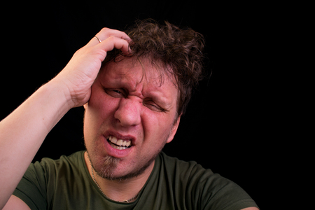 Stress. A man holds his head with his hands. He is in a state of stress.の写真素材