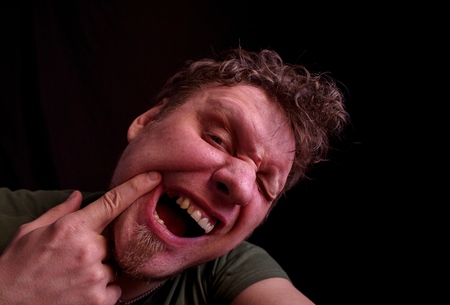 Mouth without tooth. A man looks at his teeth in the mirror.の写真素材