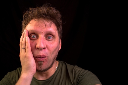 The man is sincerely very surprised. He took his face in surprise. He looks at the camera.の写真素材