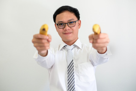 Portrait of young ceo asian businessman uses a banana instead of a gun.の写真素材
