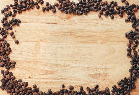 Frame made by Coffee beans on wooden table. Vintage tone.の写真素材