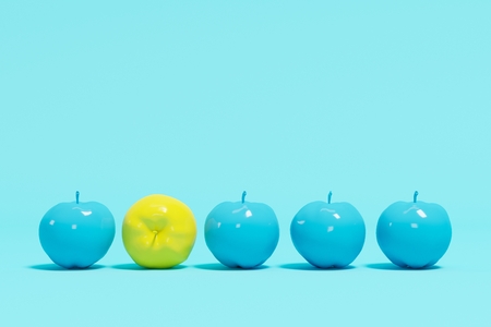 Outstanding yellow apple contrast blue appples on blue pastel background. minimal concept.の写真素材