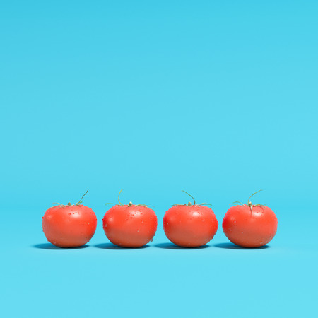 Red Tomotoes with droplet on blue background. minimal concept.の写真素材