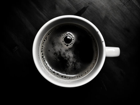 Coffee cup on black wooden table background. Top view.の素材