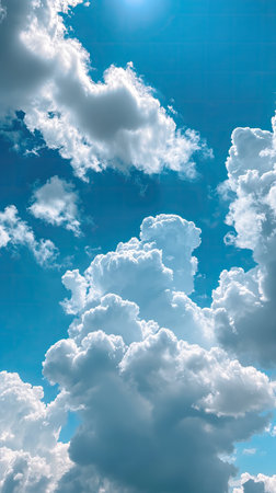 Blue sky background with white clouds and sun rays. Copy space.の素材