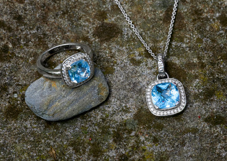 Product image of a blue Topaz Ring and necklace with diamonds presented on natural stoneの写真素材