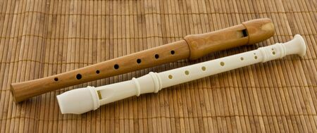 Two block flute, recorders in different colours on a brown table matの写真素材