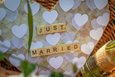 a heart with the words Just married made of single wooden letters in a basket as decoration at wedding celebrationの写真素材