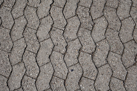 old concrete paver brick on a street surface. Made from concrete for road, path or driveways paving