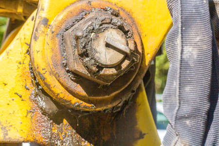 close up of a yellow joint on the arm of a shovel excavator with a lot of greaseの写真素材