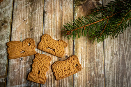 Speculaas. traditional christmas cookies on a rustic wooden surface with fir greeneryの写真素材