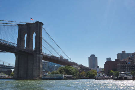 NEW YORK - CIRCA SEPTEMBER, 2017: The American flag flutters on top of the Brooklyn bridgeのeditorial素材