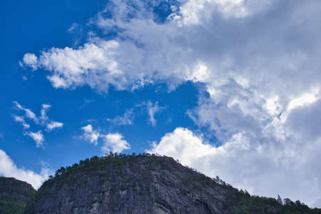 Mountain line gives nice contrast to the blue cloudy skyの写真素材