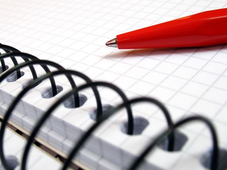 notebook with spiral and a red pen in close-upの写真素材