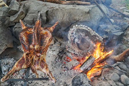 rustic lamb barbecue bbq over open fire in Patagonia, Argentina, South America. Asado is a Gaucho tradition with cooking on open flameの写真素材