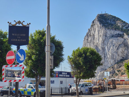 Gibraltar, United Kingdom - 06 08 2014: black and golden metal sign in the british sovereign territory in Spain saying welcome to Gibraltar with the rock of Gibraltar in the backgroundのeditorial素材