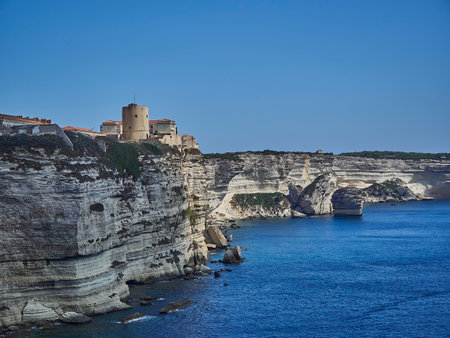 The city of Bonifacio is lying on a white cliff, surrounded by the turquoise water of the Mediterranean sea on Corsica island, Franceの写真素材