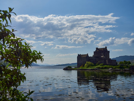 Eilean Donan, Scotland - 05 26 2018: old and historical eilean donan castle at the coastline of northern Scotland on a sunny day with reflections in the calm water of the atlantic ocean.のeditorial素材
