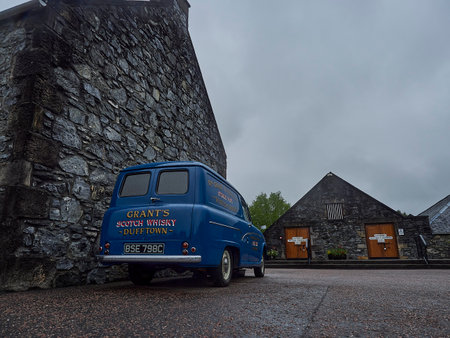 Dufftown, Scotland - 05 22 2018: blue vintage car in front of the popular and traditional Glenfiddich distillery in Scotland.のeditorial素材