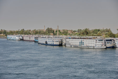 Luxor, Egypt - 05 07 2011: Luxury Nile river cruise ships lined up along the riverbank near Luxor and Theben in Egypt.のeditorial素材