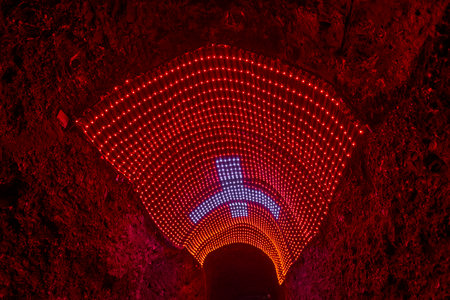 Zipaquira, Colombia - 04 12 2019: Red Switzerland flag with white cross at Catholic Cathedral of Zipaquira is built into the tunnels of an underground salt mine and artfully illuminated in colorful light.のeditorial素材