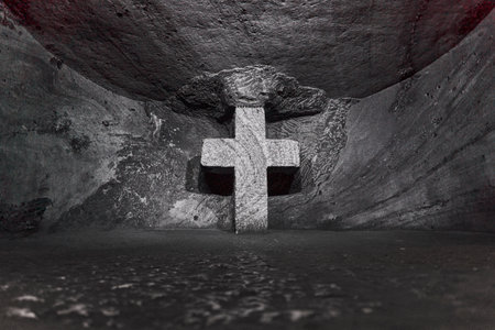 Zipaquira, Colombia - 04 12 2019: Stone cross at Catholic cathedral of Zipaquira is built into the tunnels of an underground salt mine and artfully illuminated in colorful light.のeditorial素材
