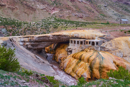Puente del Inca, Argentina - 01 13 2019: Puente del Inca, the Inca Bridge, is a natural arch that forms a bridge over the Las Cuevas River in Argentina, South America, with a natural sulfuric spring, used as a spa in an old buildingのeditorial素材
