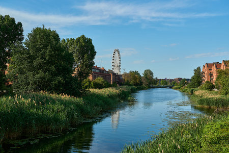 ferris wheel and historic buildings on the Motlawa River in the Old Town of Gdansk in Pomerania,...